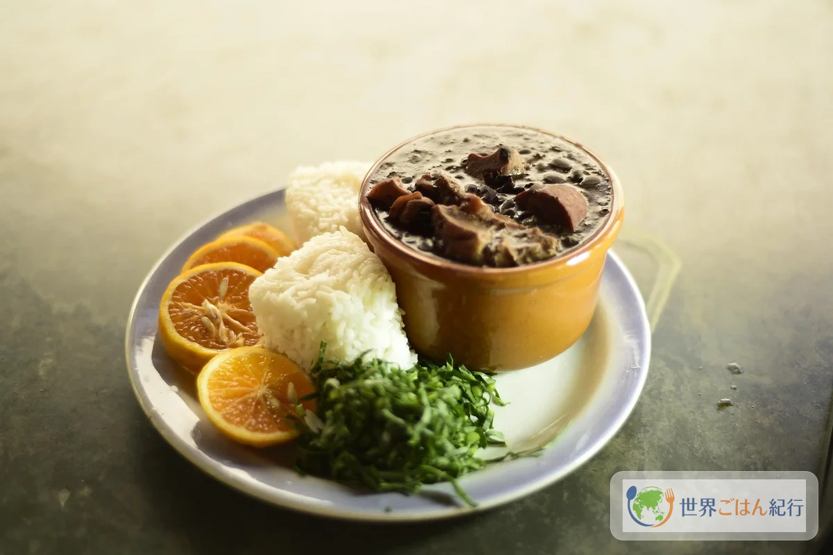 ブラジルの伝統料理が並ぶ食卓。フェイジョアーダ・ファロファ・ご飯・オレンジの典型的なプレゼンテーション