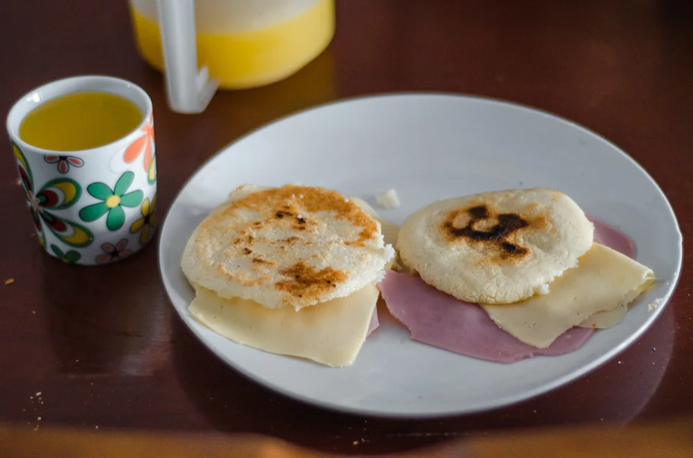 朝食の皿に並んだ小さなアレパとチーズ