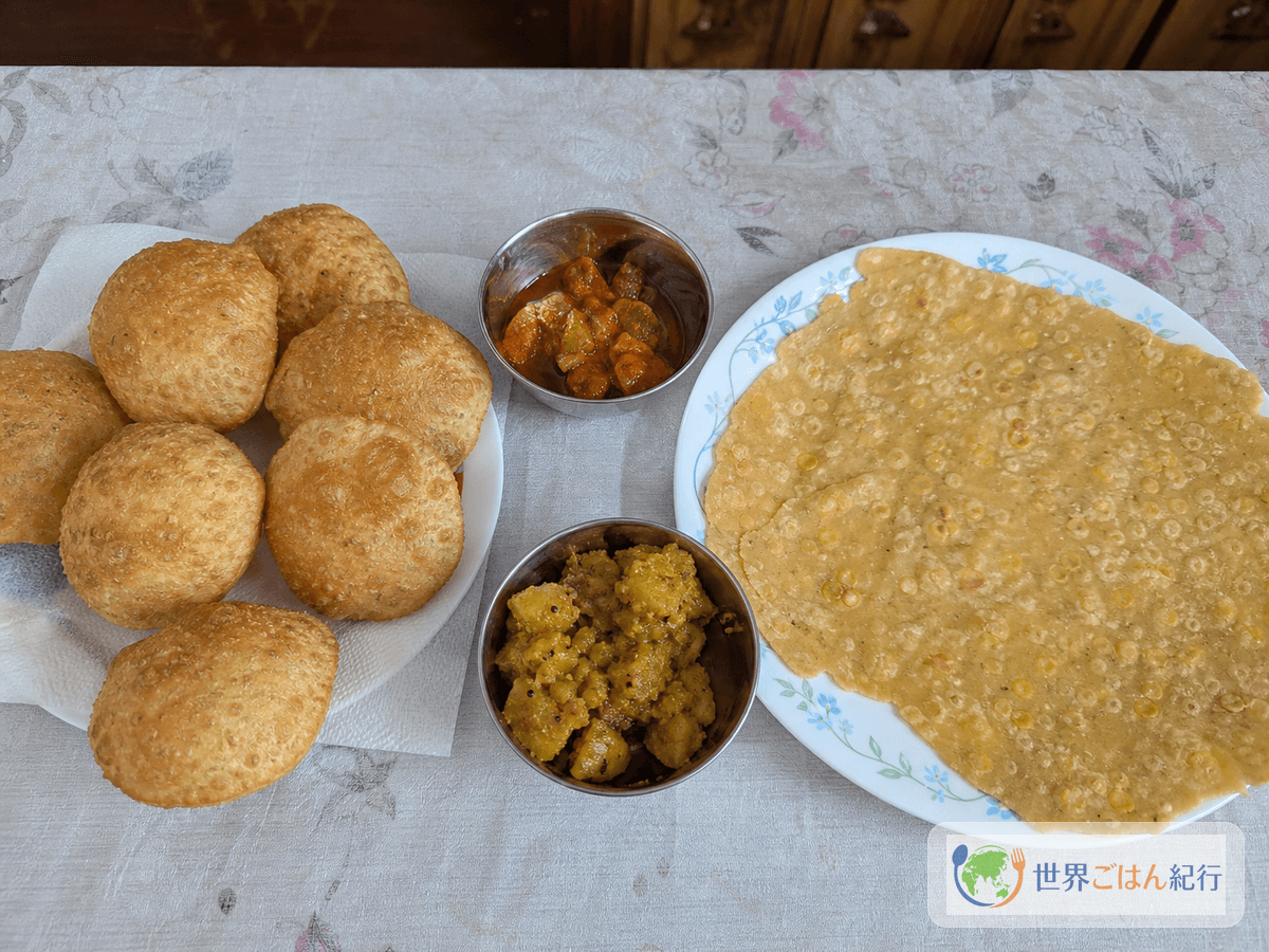 揚げるダルプリと薄焼きdhalpuri rotiを並べた食卓