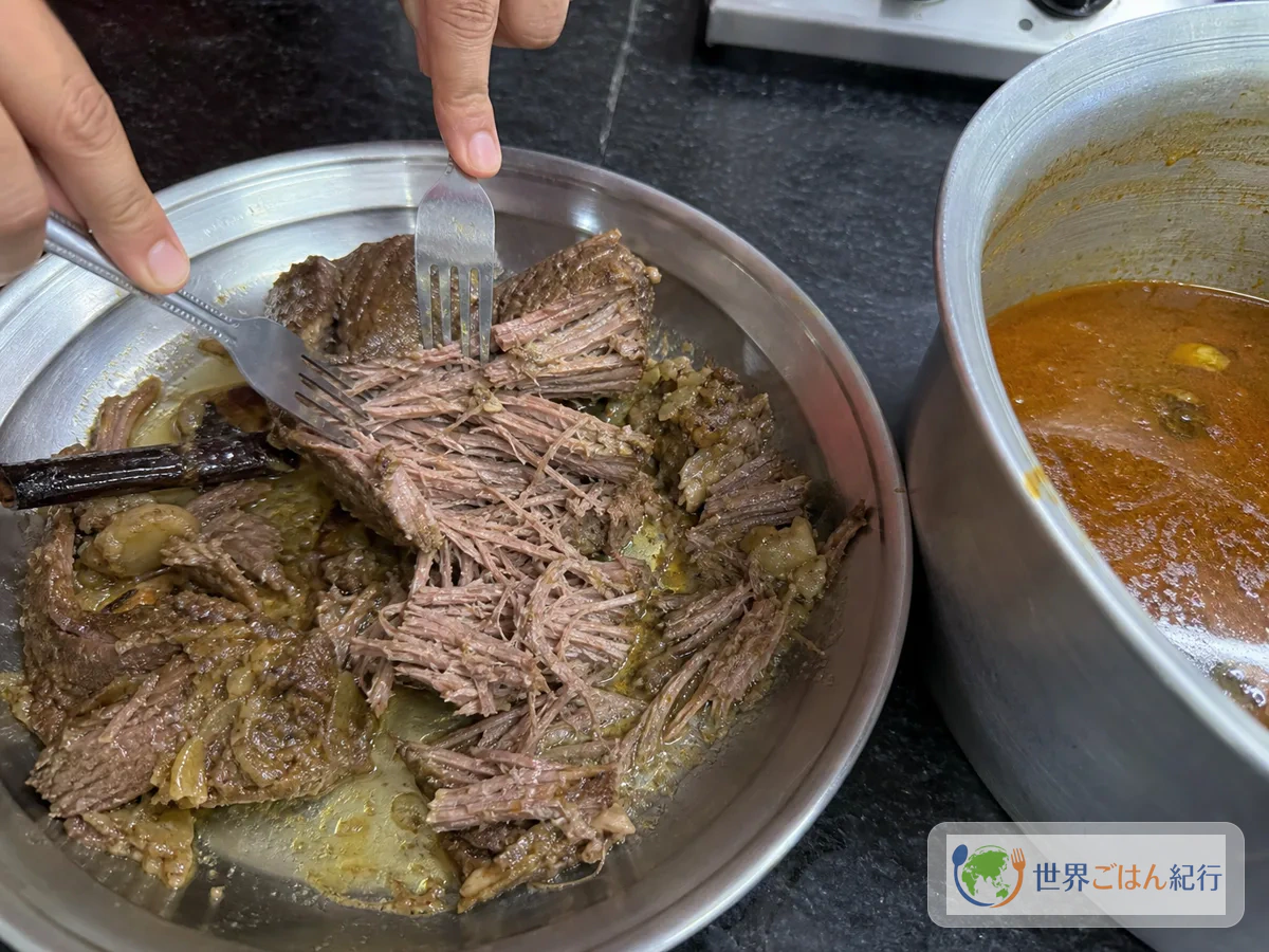 手順5: 肉をほぐして煮汁を戻す