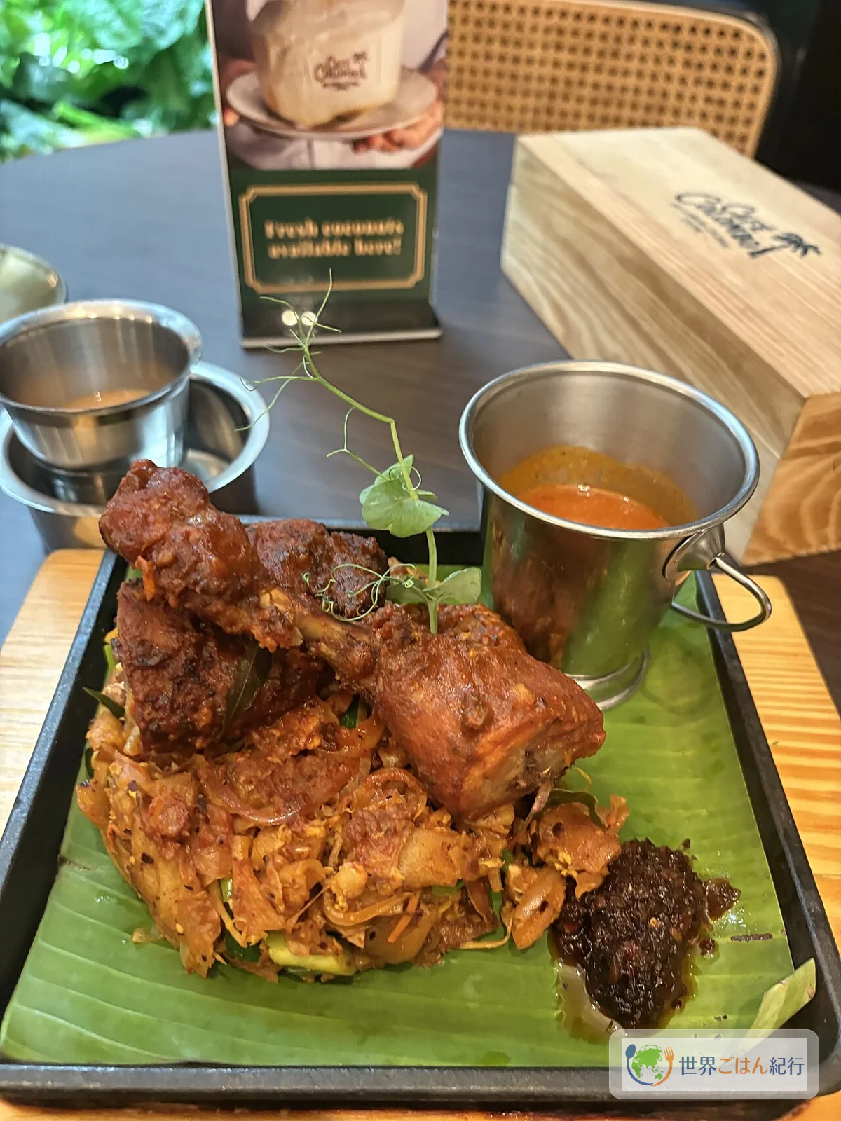 バナナリーフの上に盛り付けられたチキンコットゥとカレーソース