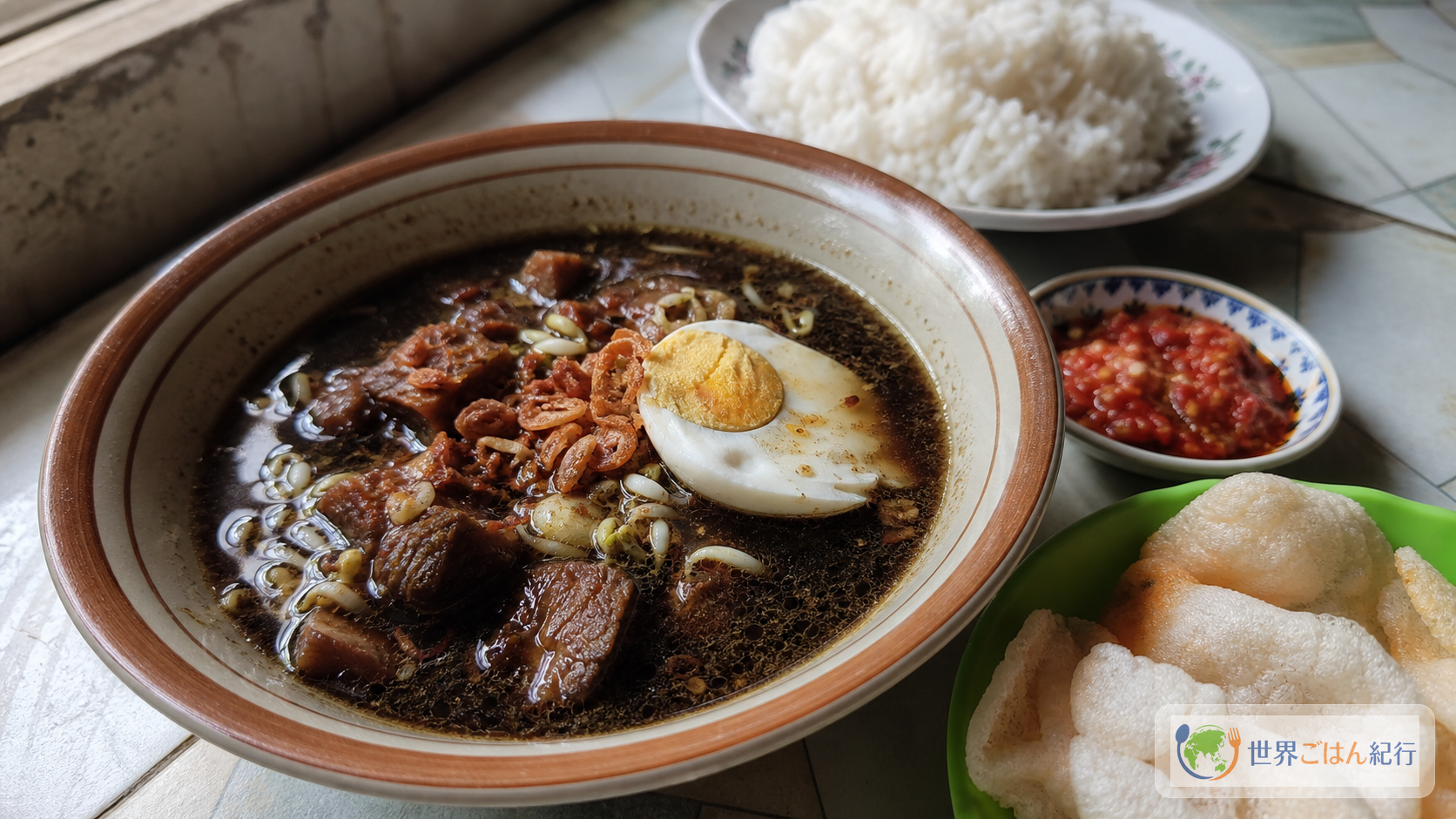 完成した黒いスープに牛肉、もやし、塩卵、フライドオニオンを添えた東ジャワ料理ラウォン