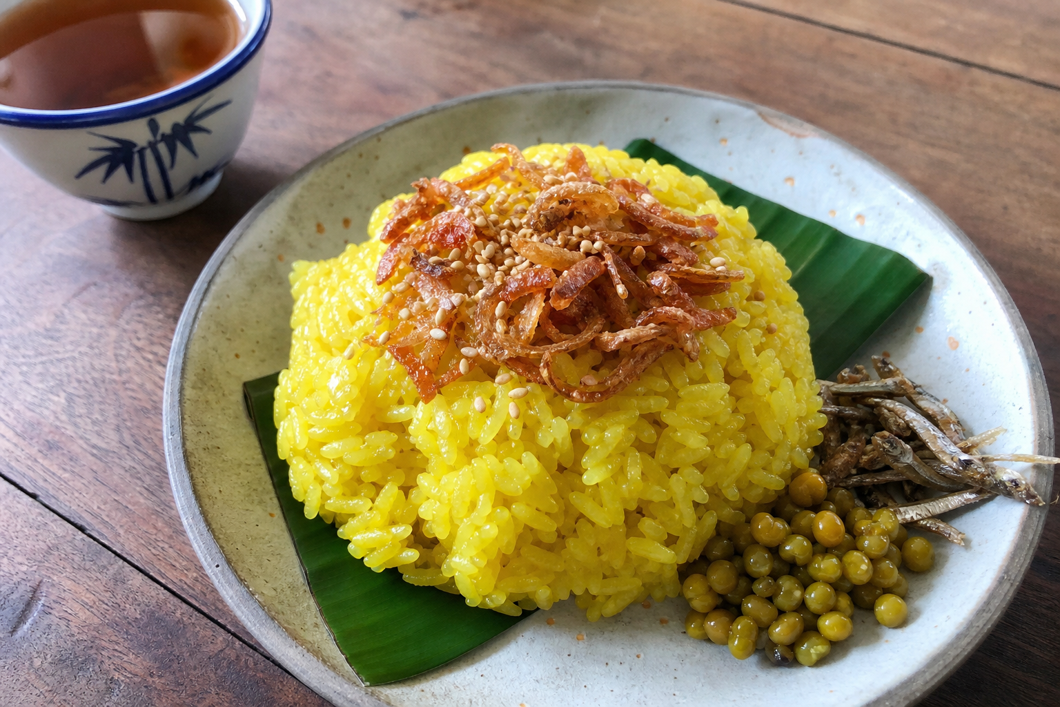 揚げ玉ねぎとごまをのせた黄色いもち米のミャンマー料理シータミン