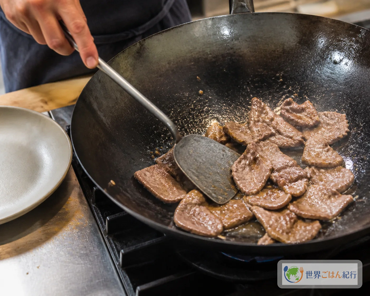 中強火のフライパンで牛肉の薄切りを焼き、表面に焼き色をつけている途中