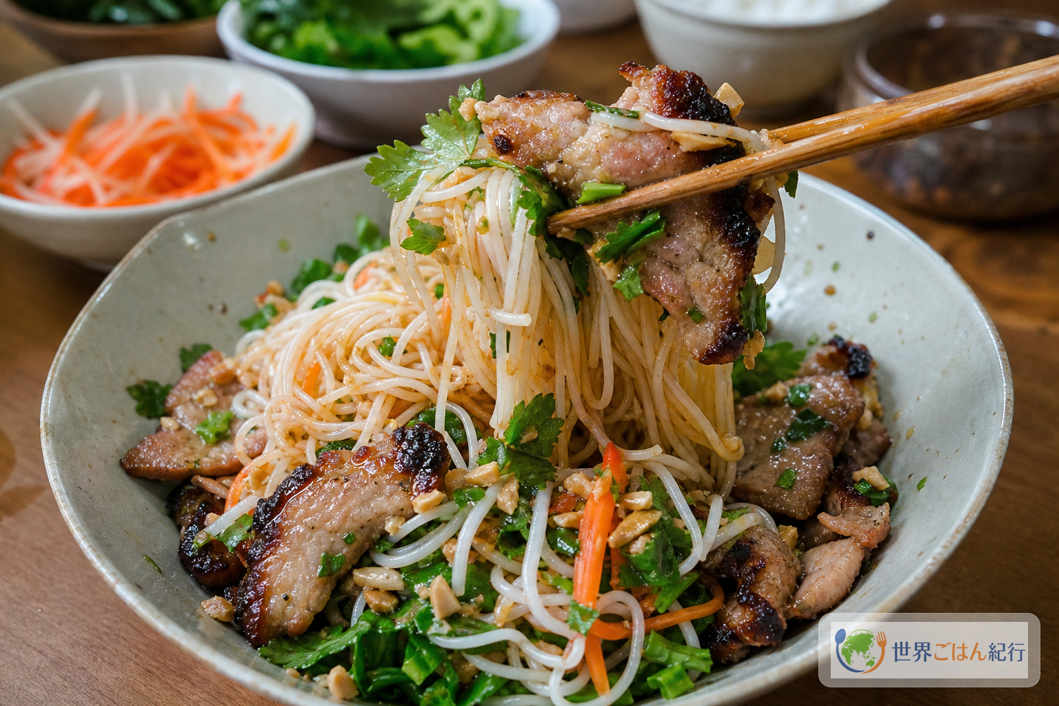 ヌクチャムで和えた米麺、焼き豚、香草を箸で持ち上げたブンティットヌン